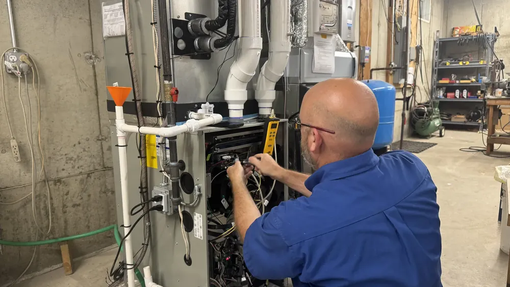 A.J. LeBlanc Heating technician performing HVAC system maintenance in Southern NH