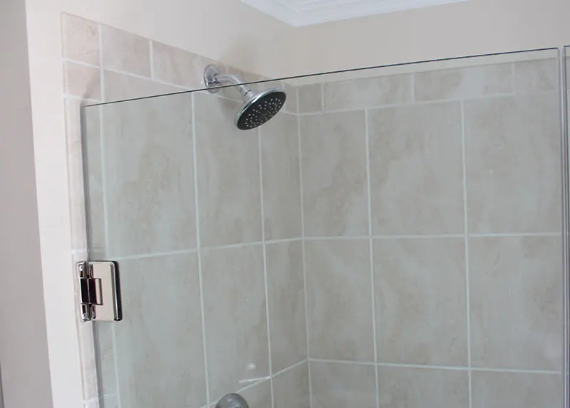 Tan square tile shower and shower head