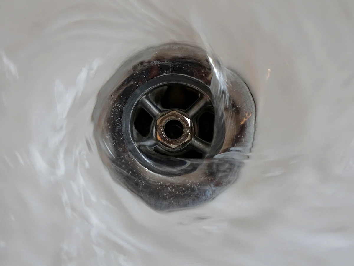 Bathtub drain repair and cleaning by A.J. LeBlanc Heating in a Southern NH bathroom