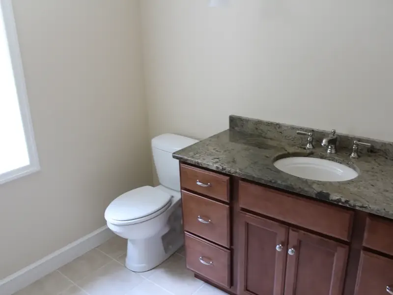 Traditional bathroom with cherry wood vanity and granite counter installed by A.J. LeBlanc Heating in a Southern NH home