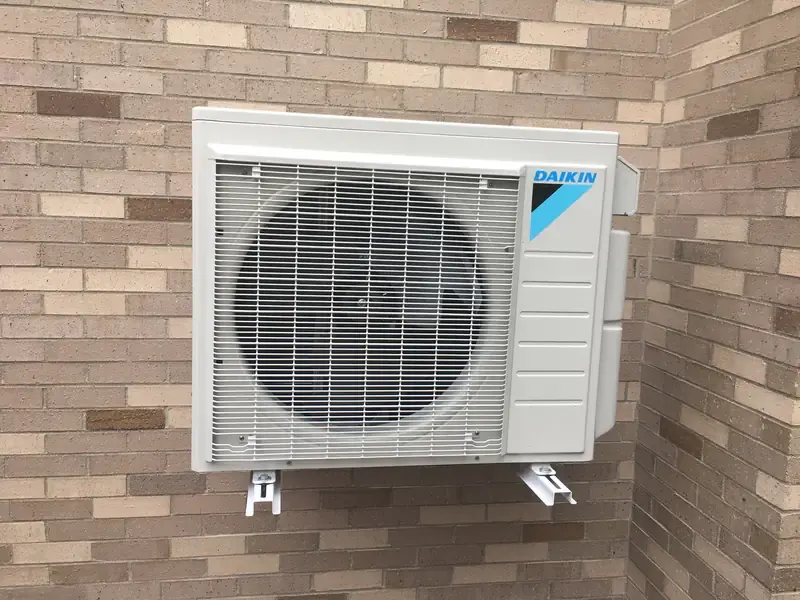 Daikin wall-mounted outdoor mini split on a brick wall in Southern NH
