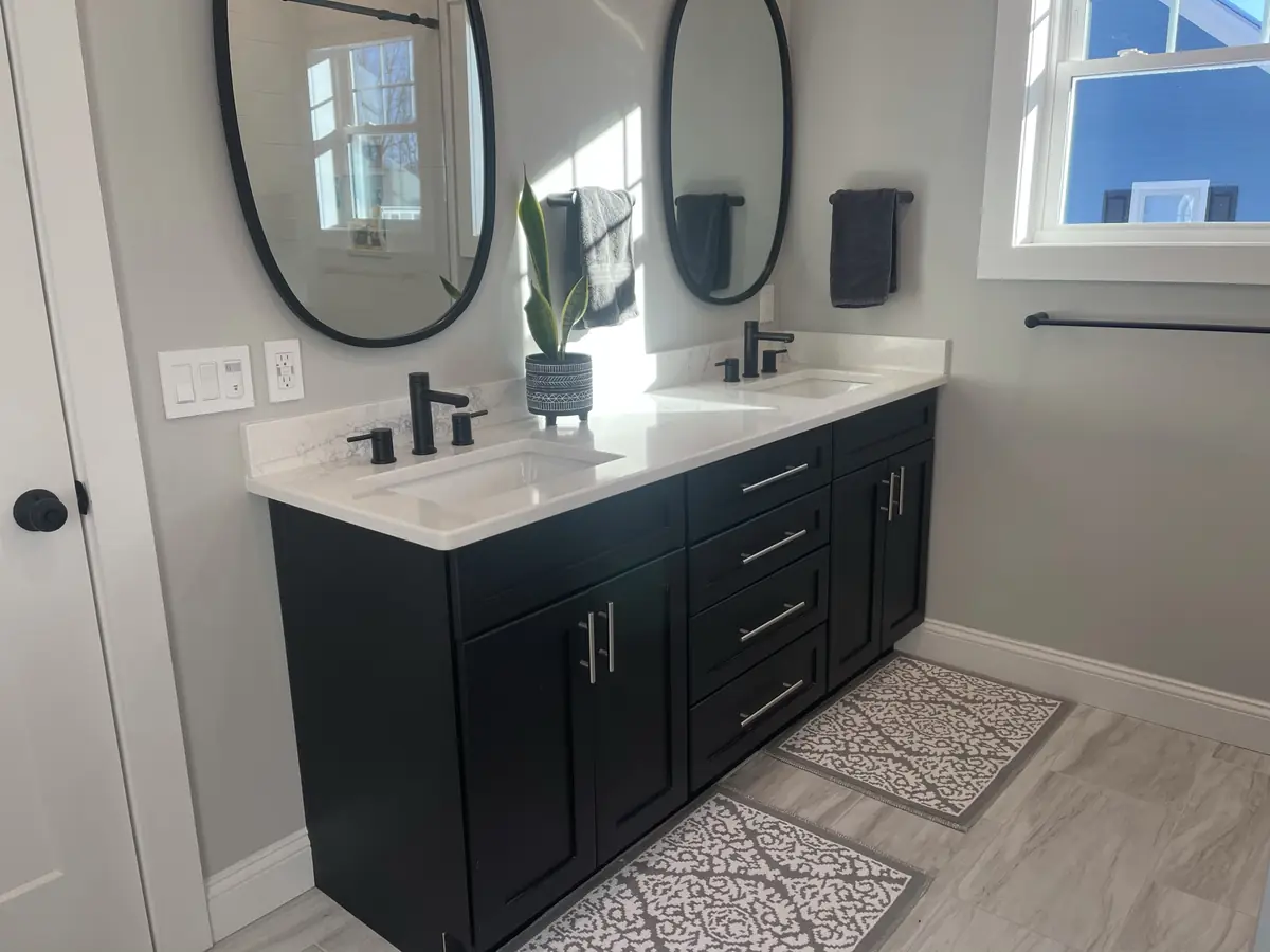Bathroom double vanity with black shaker cabinets, white quartz counter, and matte black faucets installed by A.J. LeBlanc Heating in a Southern NH home