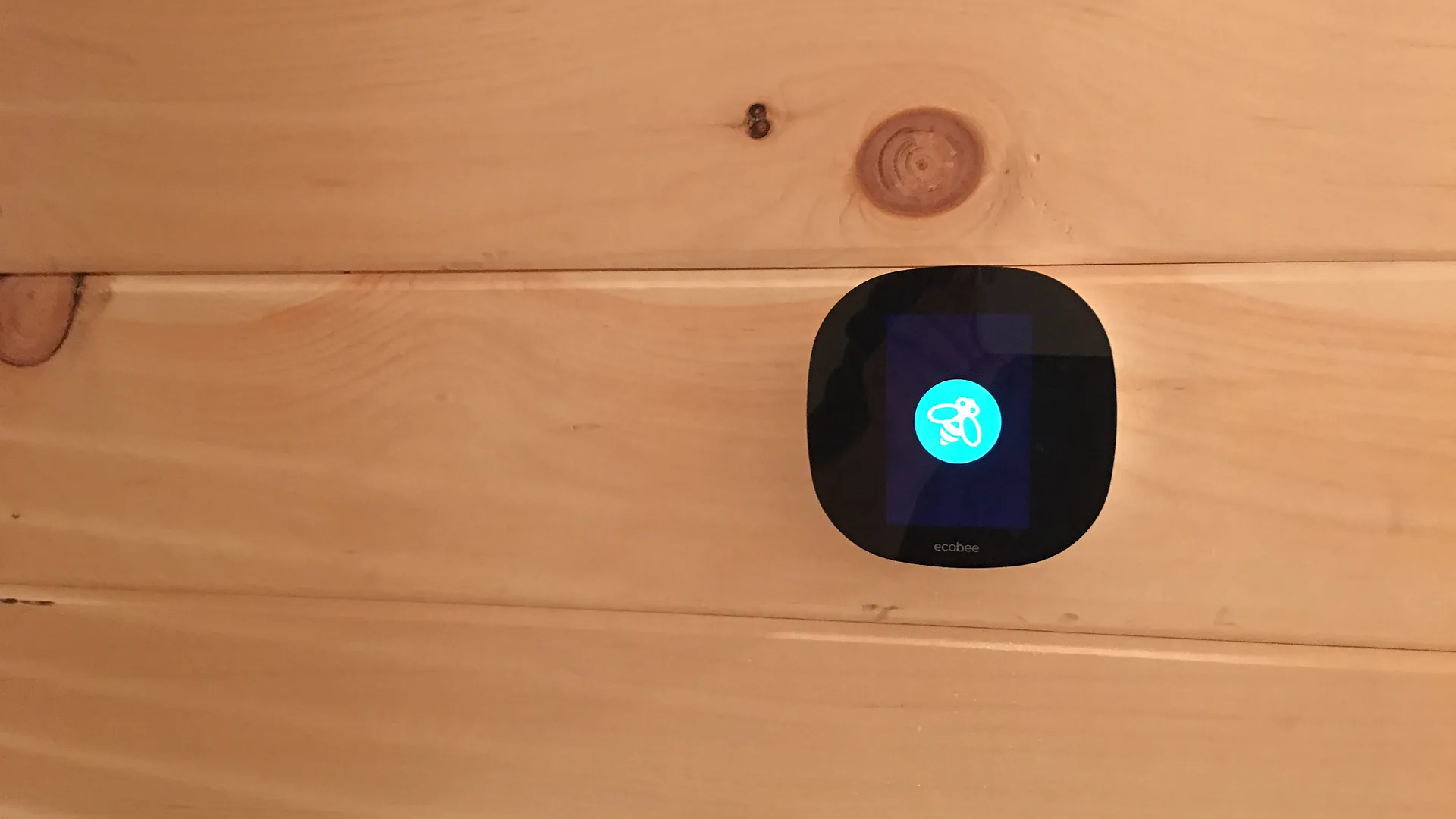 Ecobee smart thermostat installed on a pine wall in a New Hampshire home