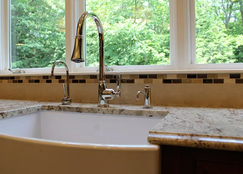 White farmhouse apron-front kitchen sink installed by A.J. LeBlanc Heating in a Southern NH home
