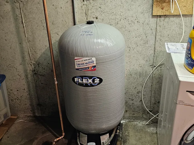 Flexcon Flex2 Pro well water pressure tank with A.J. LeBlanc Heating sticker, copper supply manifold, and shut-off valves installed in a Southern NH basement