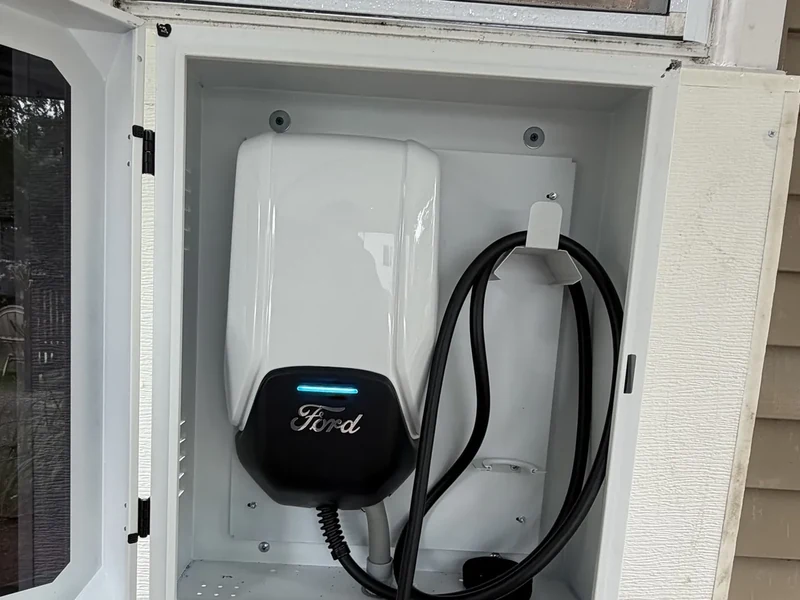Ford home EV charger mounted inside a weatherproof outdoor enclosure, installed by A.J. LeBlanc Heating in Southern NH