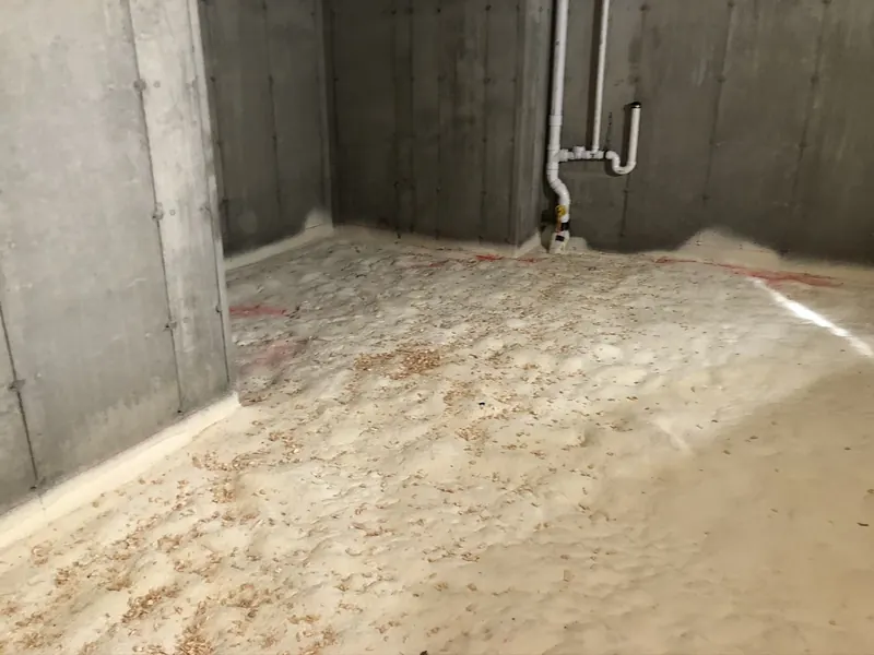 PVC plumbing vent stub-up rising through a sand base inside a new construction foundation before the basement slab is poured, by A.J. LeBlanc Heating in Southern NH