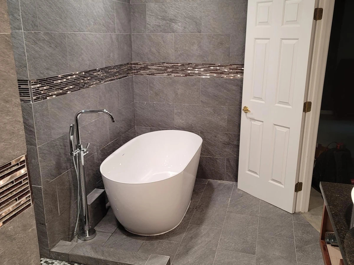 Freestanding oval bathtub and chrome floor-mount filler installed by A.J. LeBlanc Heating in a Southern NH bathroom