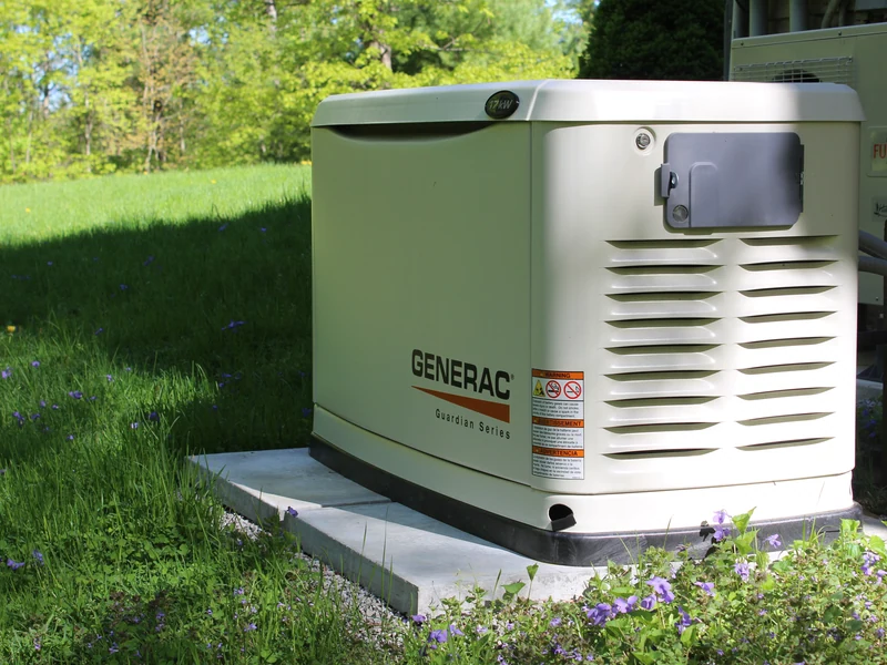 20kW Generac Guardian Series air-cooled standby generator installed in a wildflower meadow at a rural Southern NH property by A.J. LeBlanc Heating