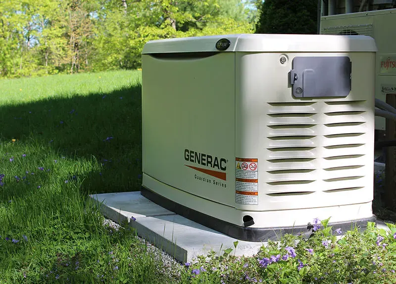 20kW Generac Guardian Series air-cooled standby generator installed in a wildflower meadow at a rural Southern NH property by A.J. LeBlanc Heating