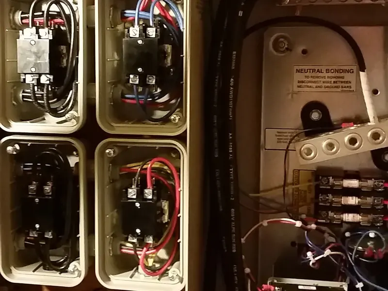 Generac whole-home automatic transfer switch wired alongside load shedding modules during a 200-amp service upgrade by A.J. LeBlanc Heating in Southern NH