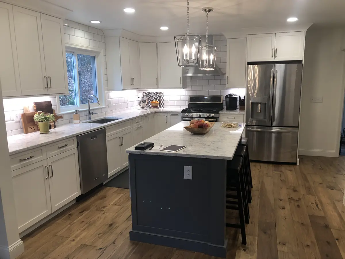 Kitchen remodel with navy blue island and marble waterfall counter installed by A.J. LeBlanc Heating in a Southern NH home