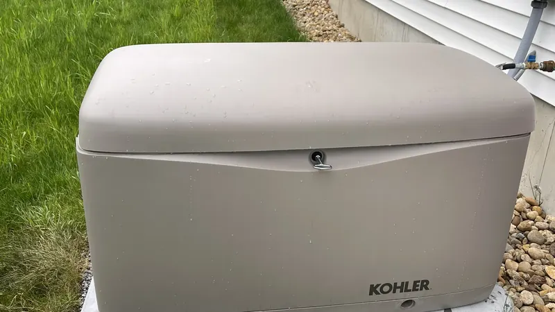 Kohler whole-home standby generator installed on a concrete pad next to a Southern NH home by A.J. LeBlanc Heating