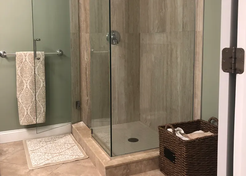 Travertine look tile shower with glass door