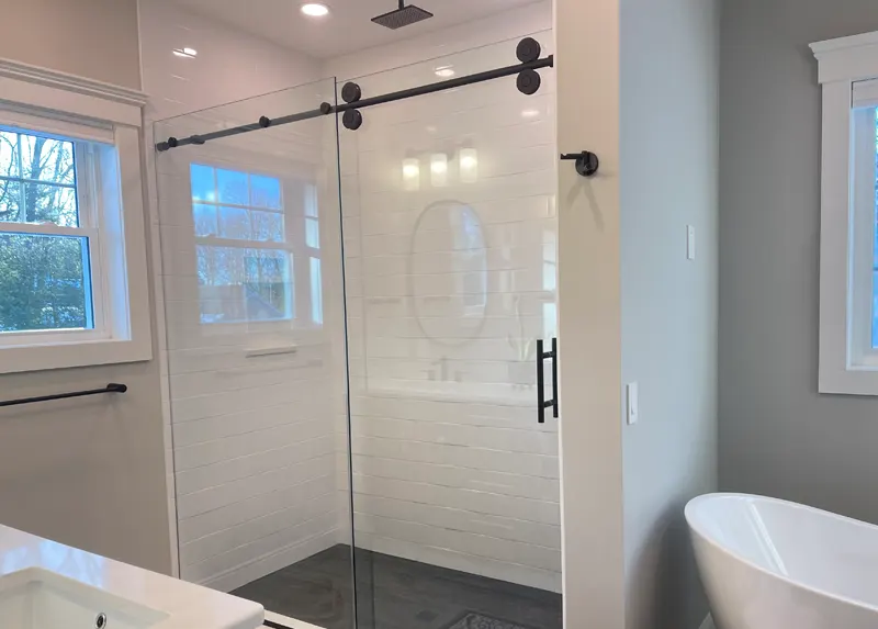 White subway tile shower with glass barn door