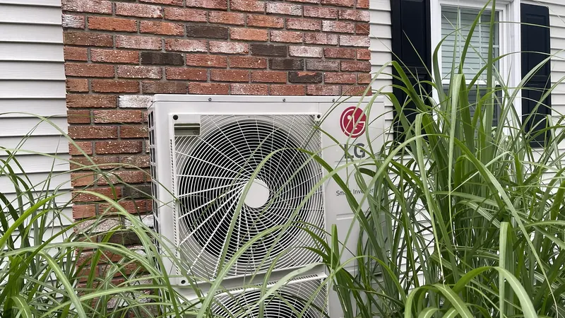 LG outdoor mini split heat pump installed against a brick wall in Southern NH