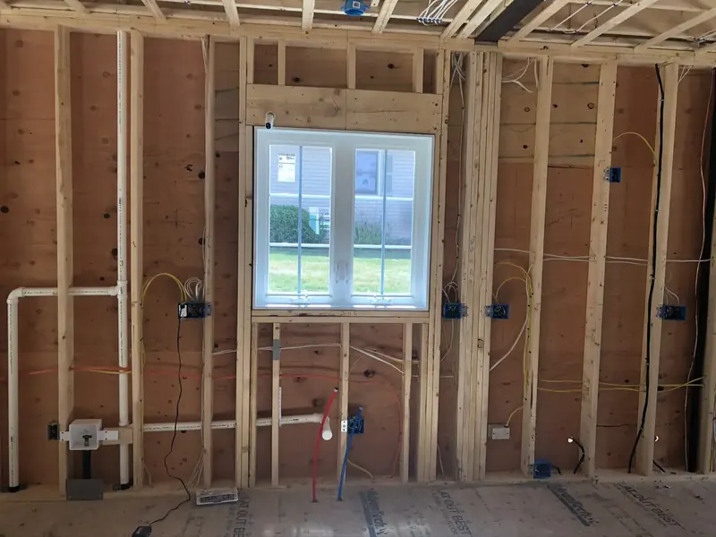 New construction wall framing with PEX hot and cold water lines and PVC drain rough-in by A.J. LeBlanc Heating in Southern NH