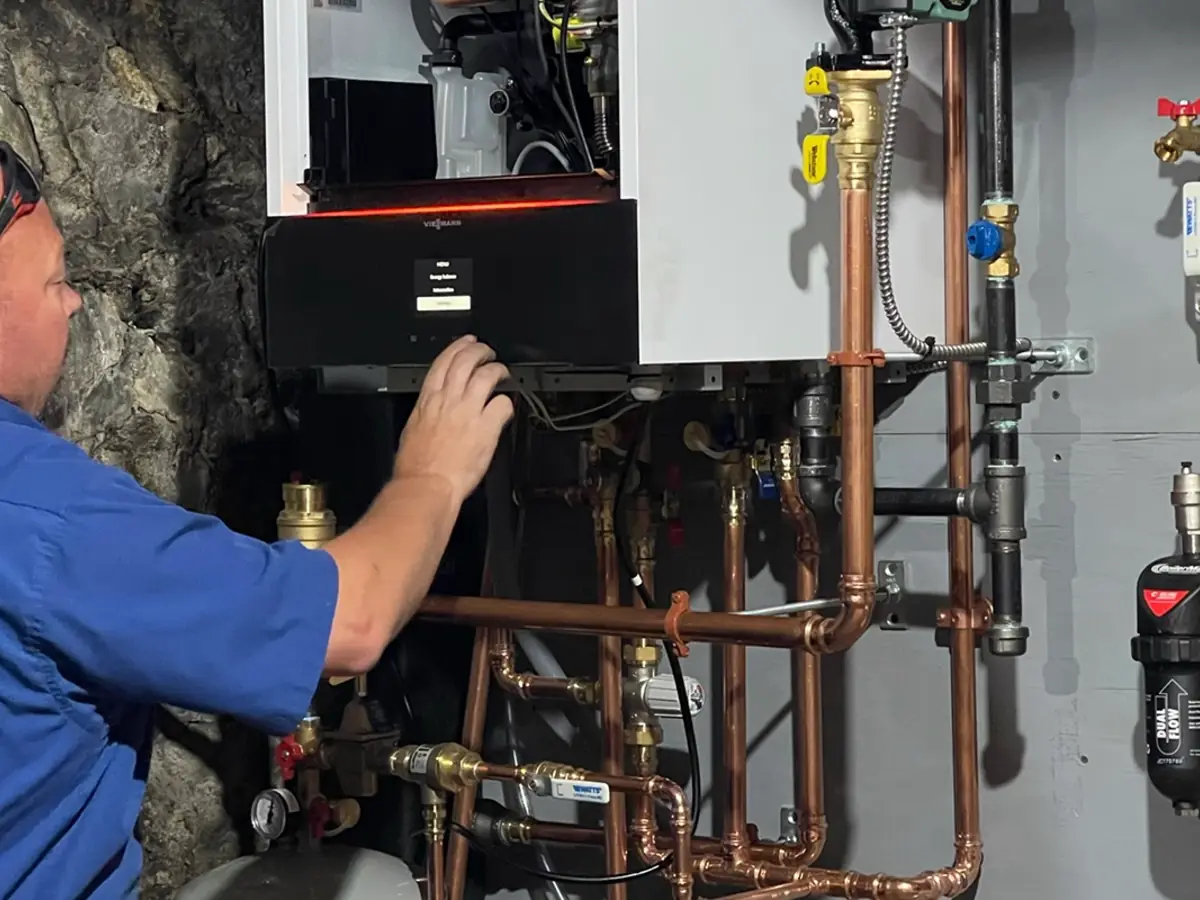Technician diagnosing a no-heat heating system in New Hampshire for A.J. LeBlanc Heating