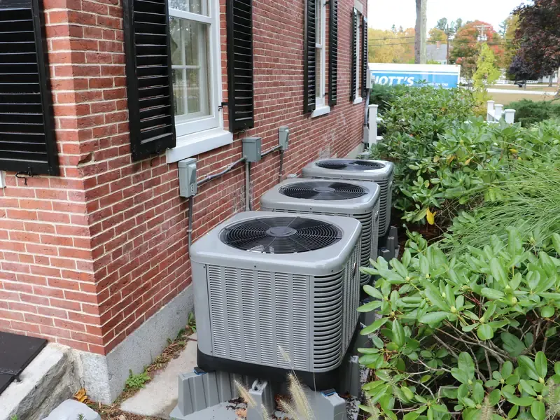 Rheem heat pump installation with three outdoor condensers at a brick Southern NH home