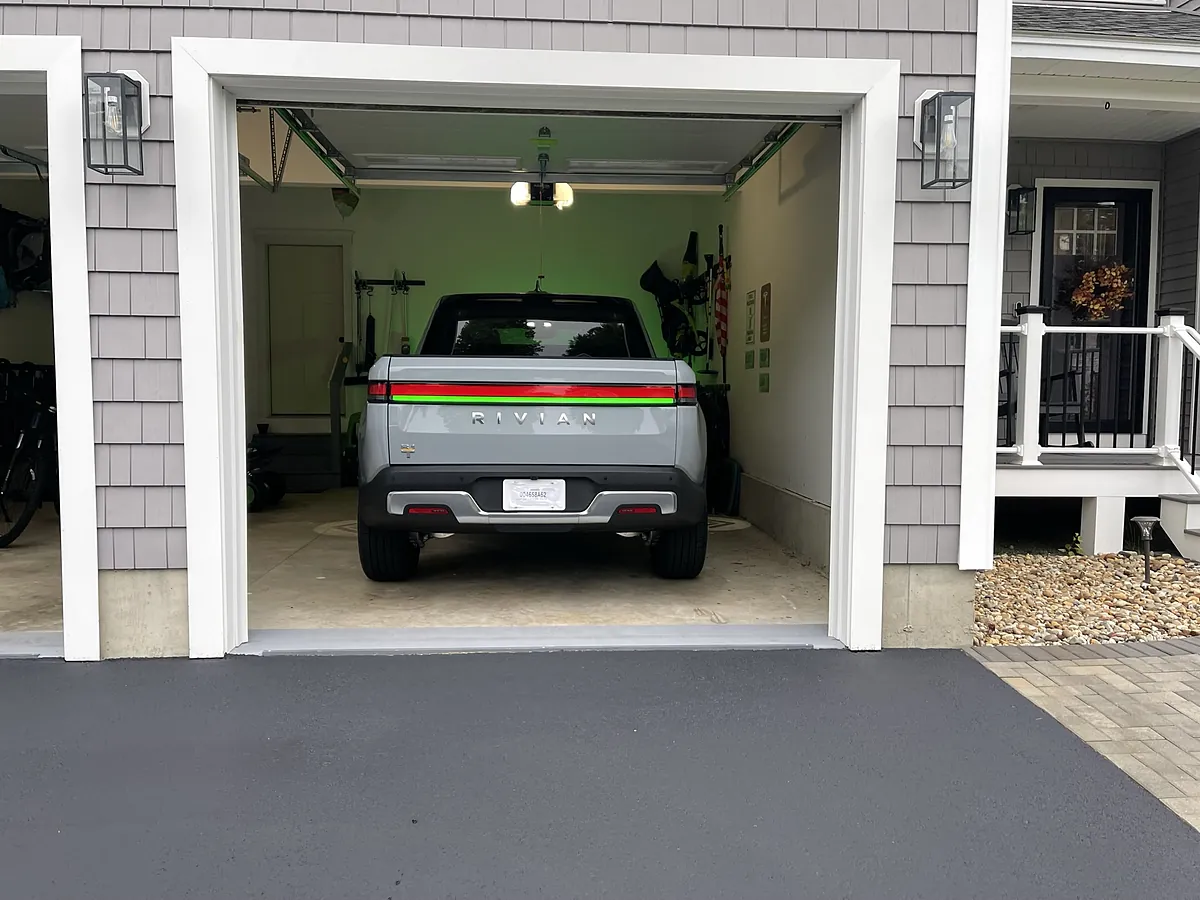 Rivian R1T parked in a residential garage with home EV charger setup in Southern NH
