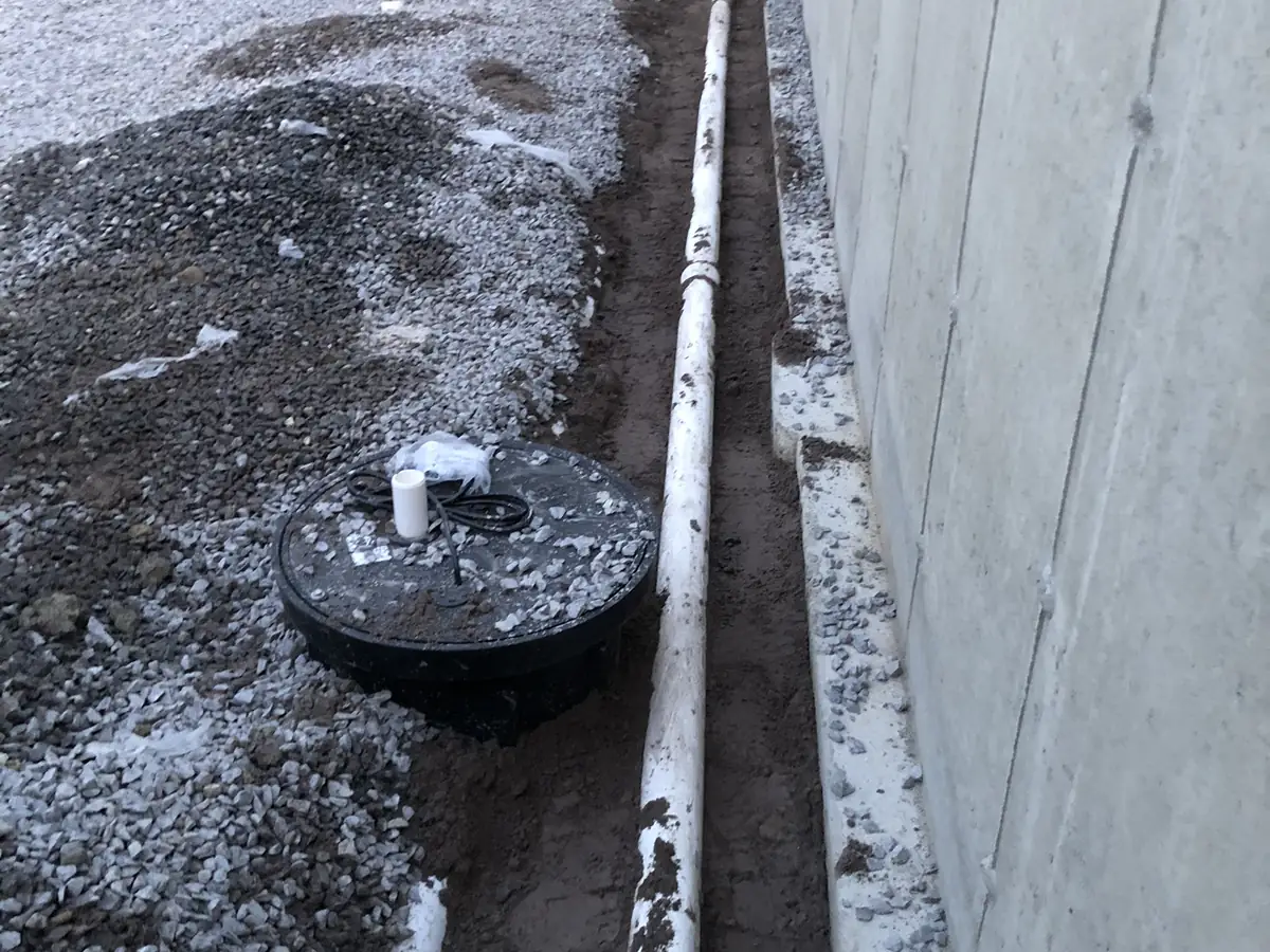 Sump pump basin and discharge in a New Hampshire basement installed by A.J. LeBlanc Heating
