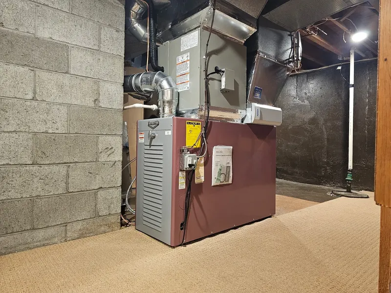 Thermo Pride oil furnace with insulated supply plenum and ductwork installed by A.J. LeBlanc Heating in a Southern NH cinder-block basement