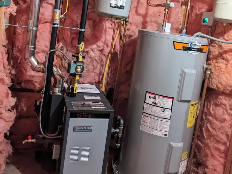 Weil-McLain gas boiler installation paired with a State ProLine electric water heater and Taco 007 circulator in a Southern NH basement